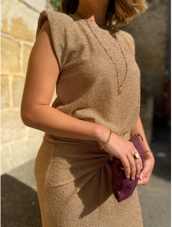 Femme portant un top sans manche à épaulette doré avec une jupe doré